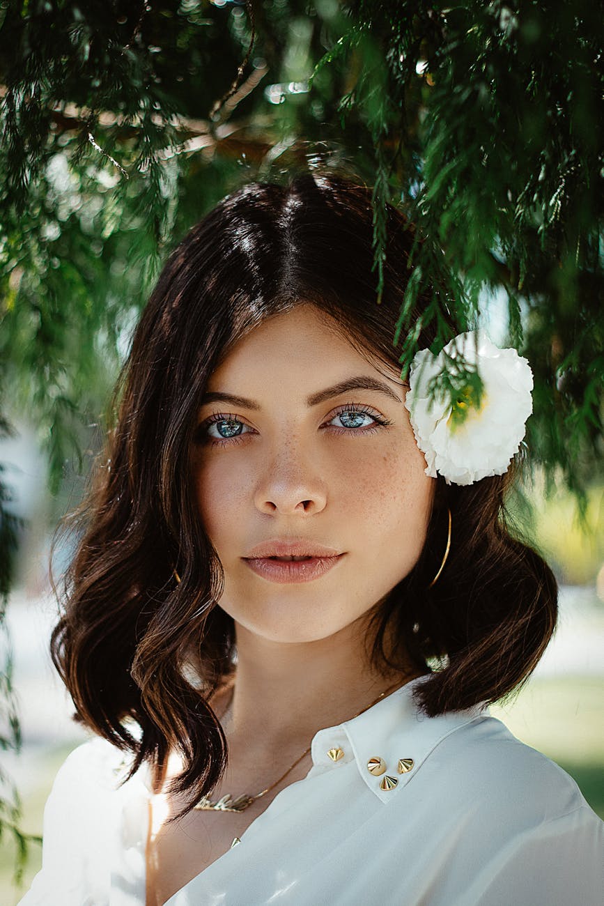 woman wearing white shirt with white flower on her ear