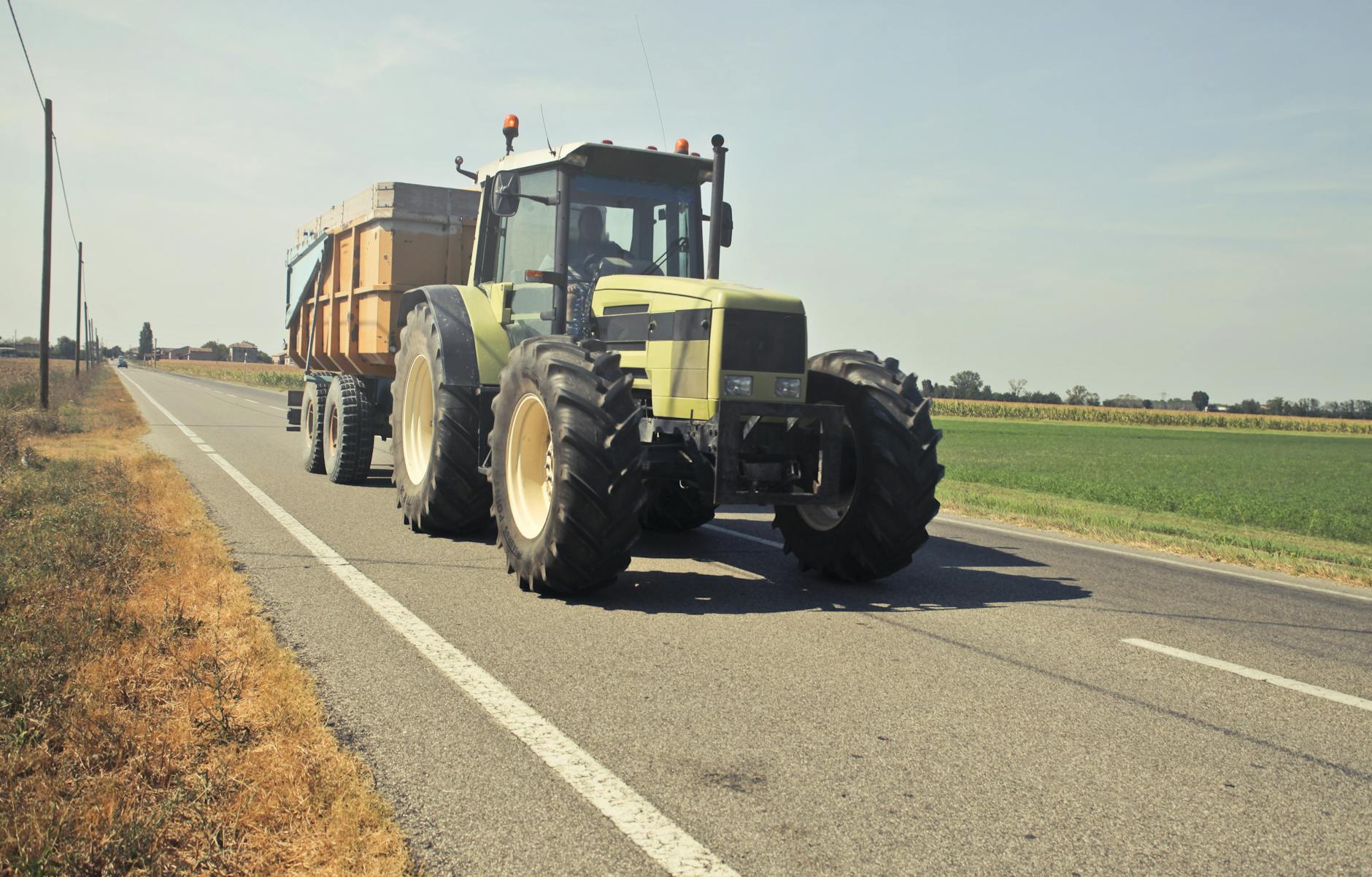 yellow tractor in asphalt road