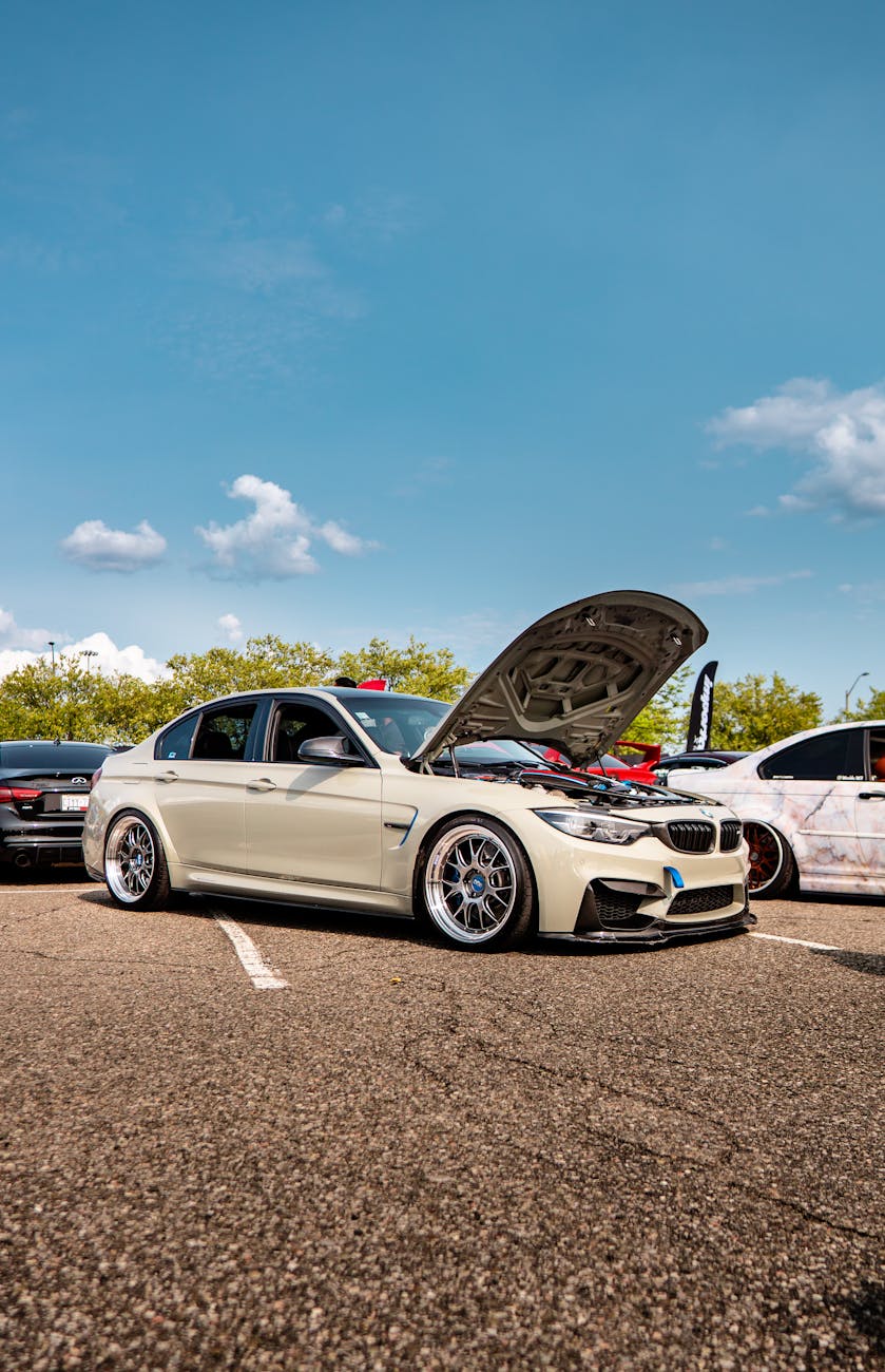 a bmw car with its hood open in a parking lot