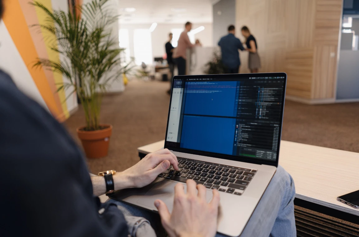 Specialist at a computer reviewing Soft2Bet's powerful betting solutions on screen